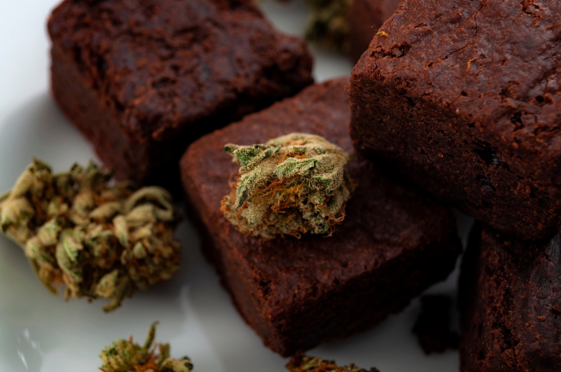 Essbares Marihuana zur Behandlung chronischer Schmerzen, alternative Medizindiät und Thema des Konzepts legalen Unkrauts mit Nahaufnahme von Cannabisblüten und leckeren Brownies